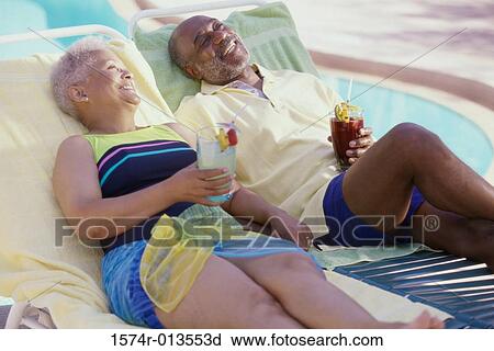 Senior couple lounging poolside View Large Photo Image Stock Image - Senior couple lounging poolside. Fotosearch