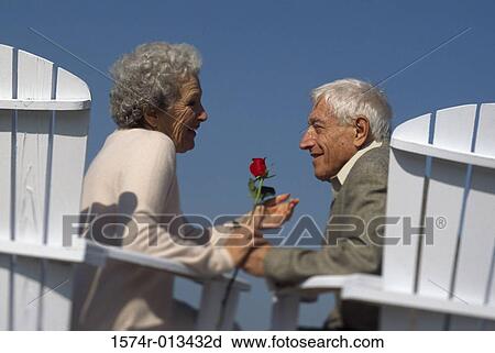 Senior couple sitting together holding hands View Large Photo Image Stock Image - Senior couple sitting together holding hands. Fotosearch