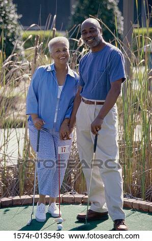 Senior couple standing on a miniature golf course View Large Photo Image Stock Image - Senior couple standing on a miniature golf course. Fotosearch