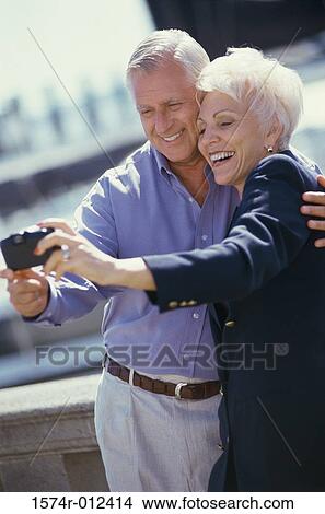 Picture - Senior couple taking a photograph of themselves. Fotosearch