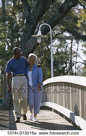 Stock Image - Senior couple walking on a bridge. Fotosearch