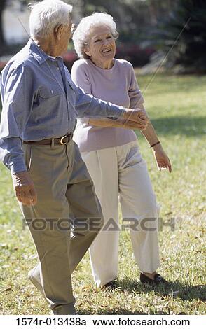 Senior couple walking on a lawn View Large Photo Image Stock Image - Senior couple walking on a lawn. Fotosearch