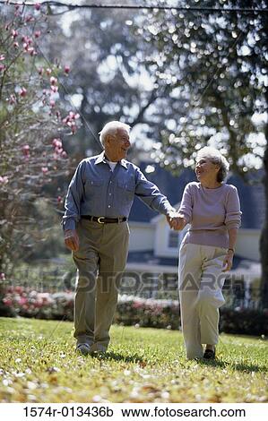 Senior couple walking together in a park View Large Photo Image Stock Image - Senior couple walking together in a park. Fotosearch