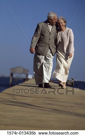 Senior couple walking together on a pier View Large Photo Image Stock Image - Senior couple walking together on a pier. Fotosearch