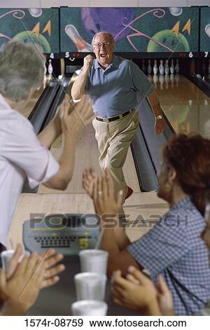 Senior man at a bowling alley with a senior couple applauding him View Large Photo Image Stock Photo - Senior man at a bowling alley with a senior couple applauding him. Fotosearch