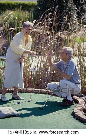Senior man cheering a senior woman on a miniature golf course View Large Photo Image Stock Image - Senior man cheering a senior woman on a miniature golf course. Fotosearch