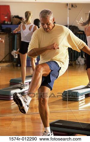 Senior man doing step aerobics in a gym View Large Photo Image Stock Image - Senior man doing step aerobics in a gym. Fotosearch