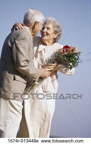 Senior man giving a bouquet of flowers to a senior woman View Large Photo Image Stock Image - Senior man giving a bouquet of flowers to a senior woman. Fotosearch