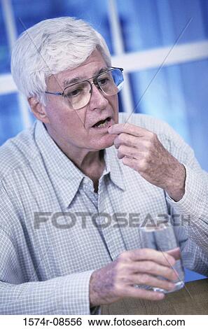 Senior man taking a pill View Large Photo Image Stock Photograph - Senior man taking a pill. Fotosearch