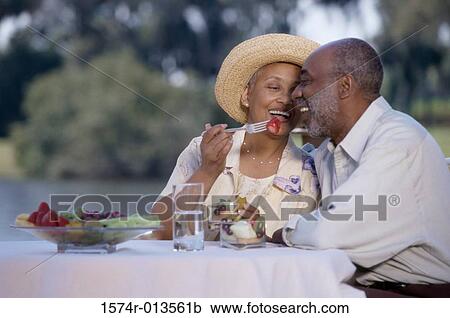 Senior woman feeding a senior man at a dining table View Large Photo Image Stock Image - Senior woman feeding a senior man at a dining table. Fotosearch