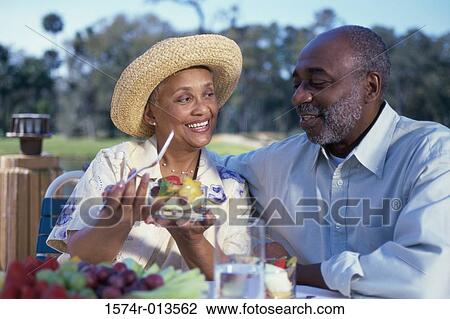 Senior woman holding a bowl of fruit salad with a senior man sitting beside her View Large Photo Image Stock Image - Senior woman holding a bowl of fruit salad with a senior man sitting beside her. Fotosearch