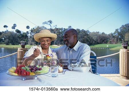 Senior woman serving a bowl of fruit salad to a senior man sitting beside her View Large Photo Image Stock Image - Senior woman serving a bowl of fruit salad to a senior man sitting beside her. Fotosearch