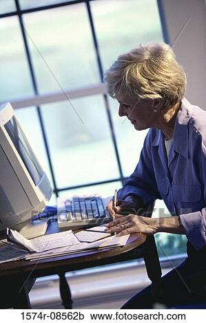 Senior woman sitting in front of a computer monitor View Large Photo Image Stock Image - Senior woman sitting in front of a computer monitor. Fotosearch