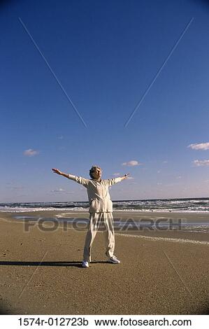 Senior woman stretching her arms on the beach View Large Photo Image Stock Image - Senior woman stretching her arms on the beach. Fotosearch