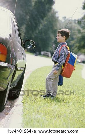Stock Image - Side profile of a boy looking at a stranger in a car. Fotosearch