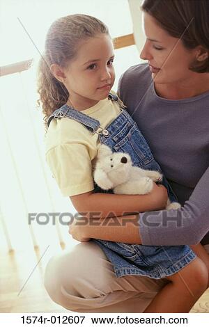 Side profile of a daughter sitting on her mother's lap View Large Photo Image Stock Photo - Side profile of a daughter sitting on her mother's lap. Fotosearch