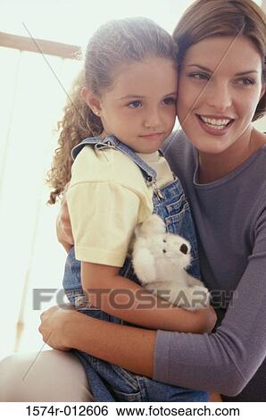 Stock Photograph - Side profile of a daughter sitting on her mother's lap. Fotosearch