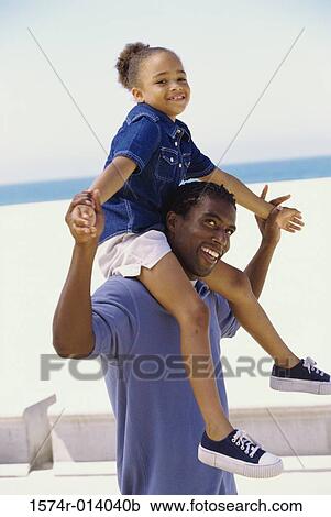 Side profile of a father carrying his daughter on his shoulders View Large Photo Image Stock Image - Side profile of a father carrying his daughter on his shoulders. Fotosearch
