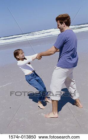 Side profile of a father playing with his daughter on the beach View Large Photo Image Stock Image - Side profile of a father playing with his daughter on the beach. Fotosearch