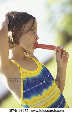 Side profile of a girl eating an ice cream View Large Photo Image Stock Photography - Side profile of a girl eating an ice cream. Fotosearch