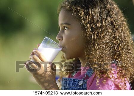 Side profile of a girl holding a glass of milk View Large Photo Image Stock Image - Side profile of a girl holding a glass of milk. Fotosearch