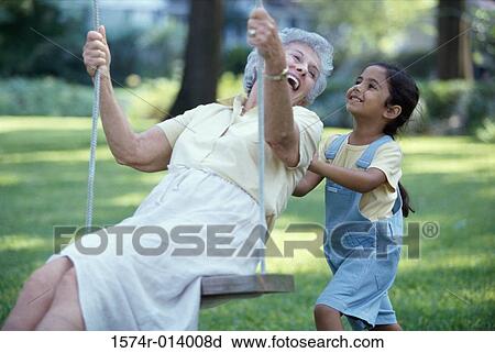Side profile of a granddaughter pushing her grandmother on a swing View Large Photo Image Stock Image - Side profile of a granddaughter pushing her grandmother on a swing. Fotosearch