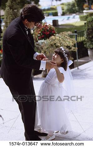 Stock Photo - Side profile of a groom dancing with a flower girl. Fotosearch