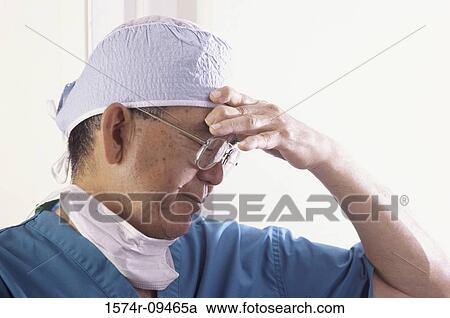Side profile of a male doctor with his hand on his head View Large Photo Image Stock Image - Side profile of a male doctor with his hand on his head. Fotosearch