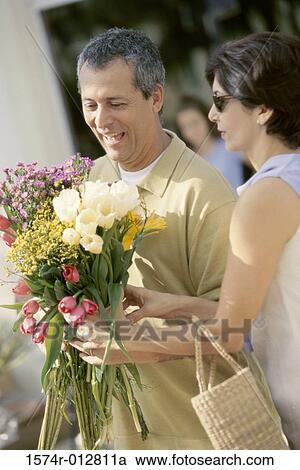 Side profile of a mature couple holding a bouquet of flowers View Large Photo Image Stock Image - Side profile of a mature couple holding a bouquet of flowers. Fotosearch
