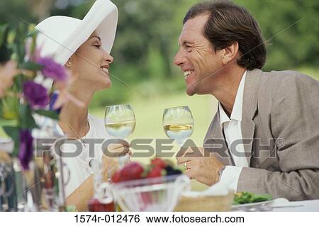 Side profile of a mature couple holding wineglasses View Large Photo Image Stock Photograph - Side profile of a mature couple holding wineglasses. Fotosearch