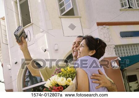 Side profile of a mature couple taking a photograph of themselves View Large Photo Image Stock Image - Side profile of a mature couple taking a photograph of themselves. Fotosearch