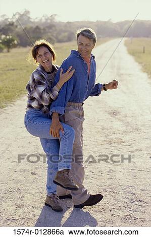 Side profile of a mid adult couple standing together on a road View Large Photo Image Stock Image - Side profile of a mid adult couple standing together on a road. Fotosearch