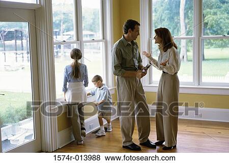 Side profile of a mid adult couple talking to each other View Large Photo Image Stock Photo - Side profile of a mid adult couple talking to each other. Fotosearch