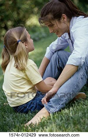 Side profile of a mother and daughter sitting in a park View Large Photo Image Stock Photo - Side profile of a mother and daughter sitting in a park. Fotosearch