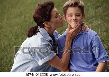 Side profile of a mother kissing her son View Large Photo Image Stock Photo - Side profile of a mother kissing her son. Fotosearch