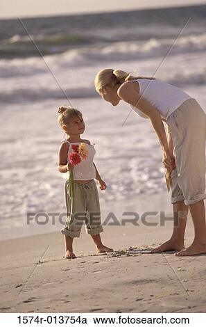 Side profile of a mother talking to her daughter on the beach View Large Photo Image Stock Image - Side profile of a mother talking to her daughter on the beach. Fotosearch