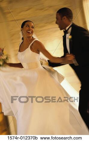 Stock Image - Side profile of a newlywed couple dancing. Fotosearch