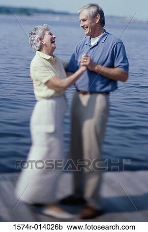 Side profile of a senior couple dancing on a pier View Large Photo Image Stock Image - Side profile of a senior couple dancing on a pier. Fotosearch