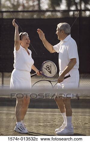 Side profile of a senior couple giving high-five to each other View Large Photo Image Stock Image - Side profile of a senior couple giving high-five to each other. Fotosearch