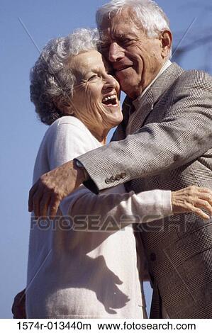 Picture - Side profile of a senior couple embracing each other. Fotosearch