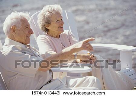 Side profile of a senior couple sitting on the beach View Large Photo Image Stock Image - Side profile of a senior couple sitting on the beach. Fotosearch