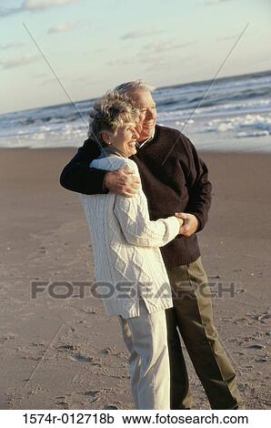 Side profile of a senior couple embracing each other on the beach View Large Photo Image Stock Image - Side profile of a senior couple embracing each other on the beach. Fotosearch