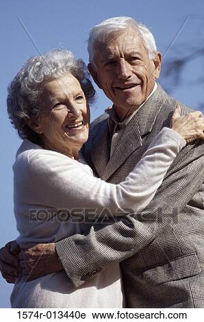 Stock Image - Side profile of a senior couple embracing each other. Fotosearch