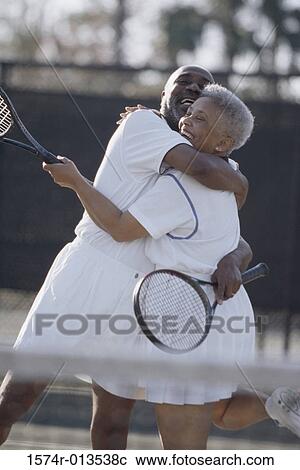 Side profile of a senior couple embracing each other on a tennis court View Large Photo Image Stock Image - Side profile of a senior couple embracing each other on a tennis court. Fotosearch