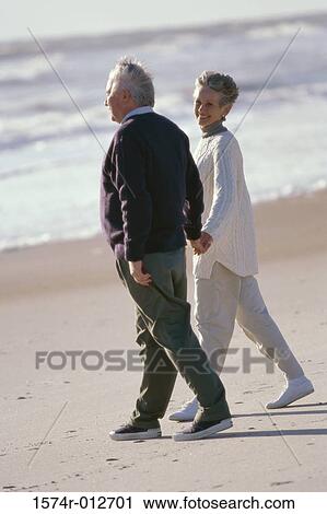 Side profile of a senior couple walking on the beach View Large Photo Image Stock Image - Side profile of a senior couple walking on the beach. Fotosearch