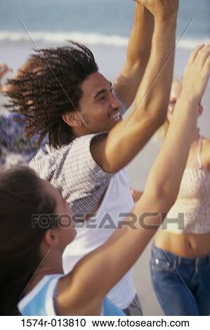 Side profile of a teenage boy and two teenage girls with their arms raised View Large Photo Image Stock Image - Side profile of a teenage boy and two teenage girls with their arms raised. Fotosearch