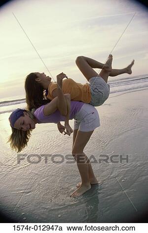 Side profile of a teenage girl carrying another on her back View Large Photo Image Stock Image - Side profile of a teenage girl carrying another on her back. Fotosearch