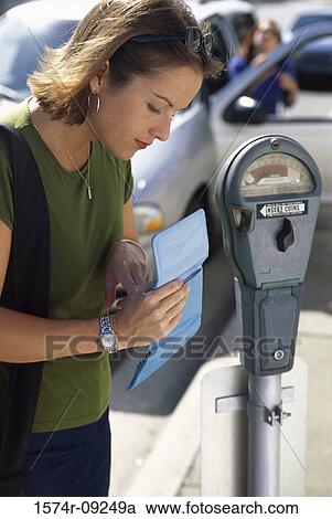 Stock Image - Side profile of a woman looking for change in her purse. Fotosearch