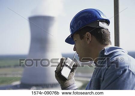 Side profile of a worker talking on a walkie-talkie at a power plant View Large Photo Image Stock Image - Side profile of a worker talking on a walkie-talkie at a power plant. Fotosearch