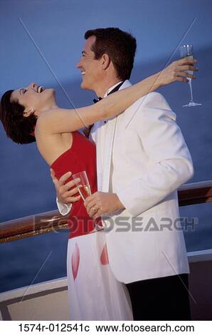 Stock Image - Side profile of a young couple embracing each other on a cruise ship. Fotosearch